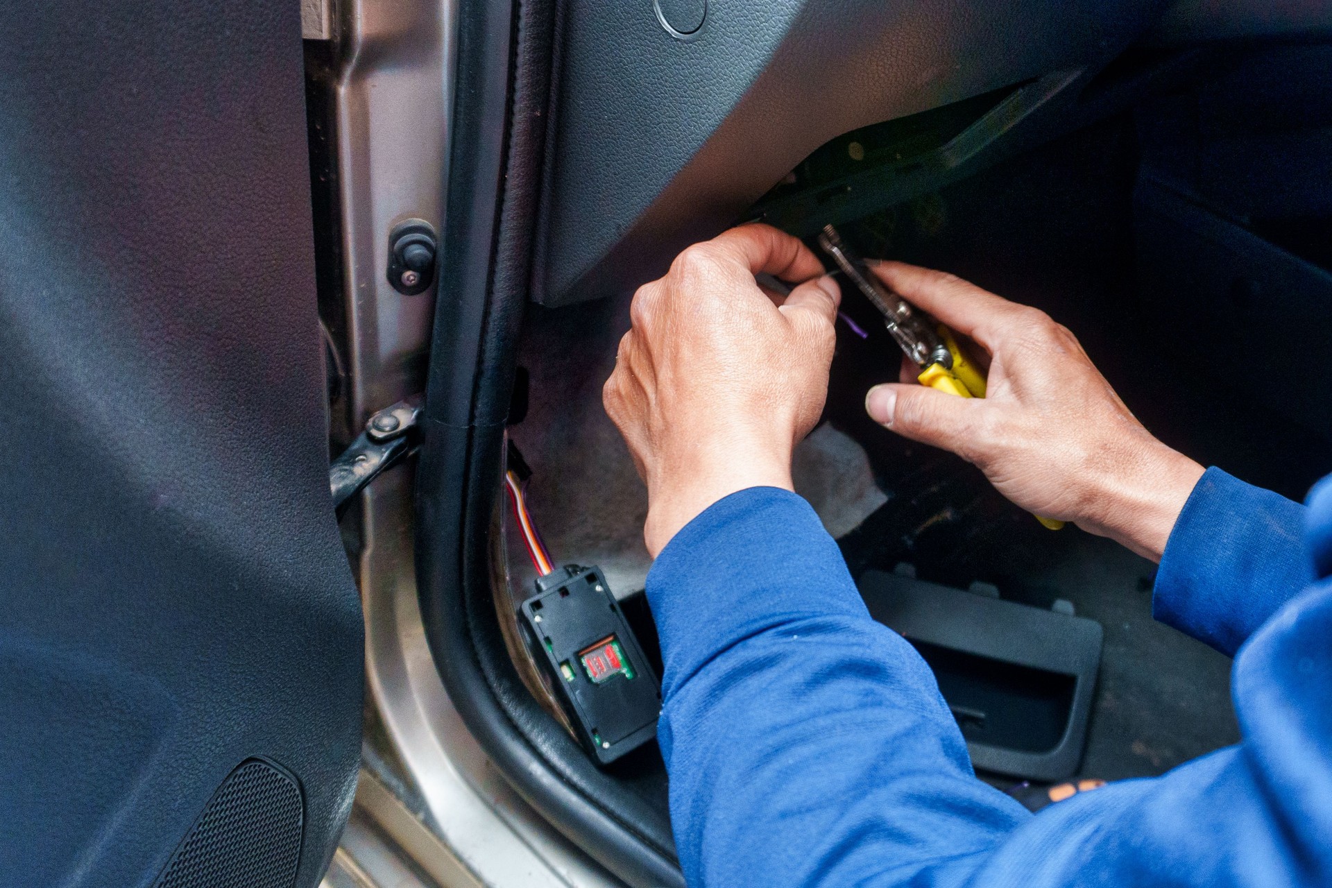a man installing an electronic satellite positioning device in a car.